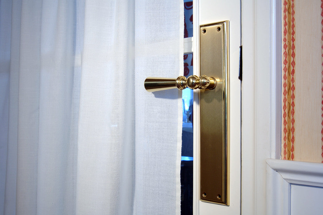 Urbe Door lever handles set on plates in interior - Bronces Mestre