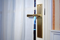 Urbe Door lever handles set on plates in interior - Bronces Mestre