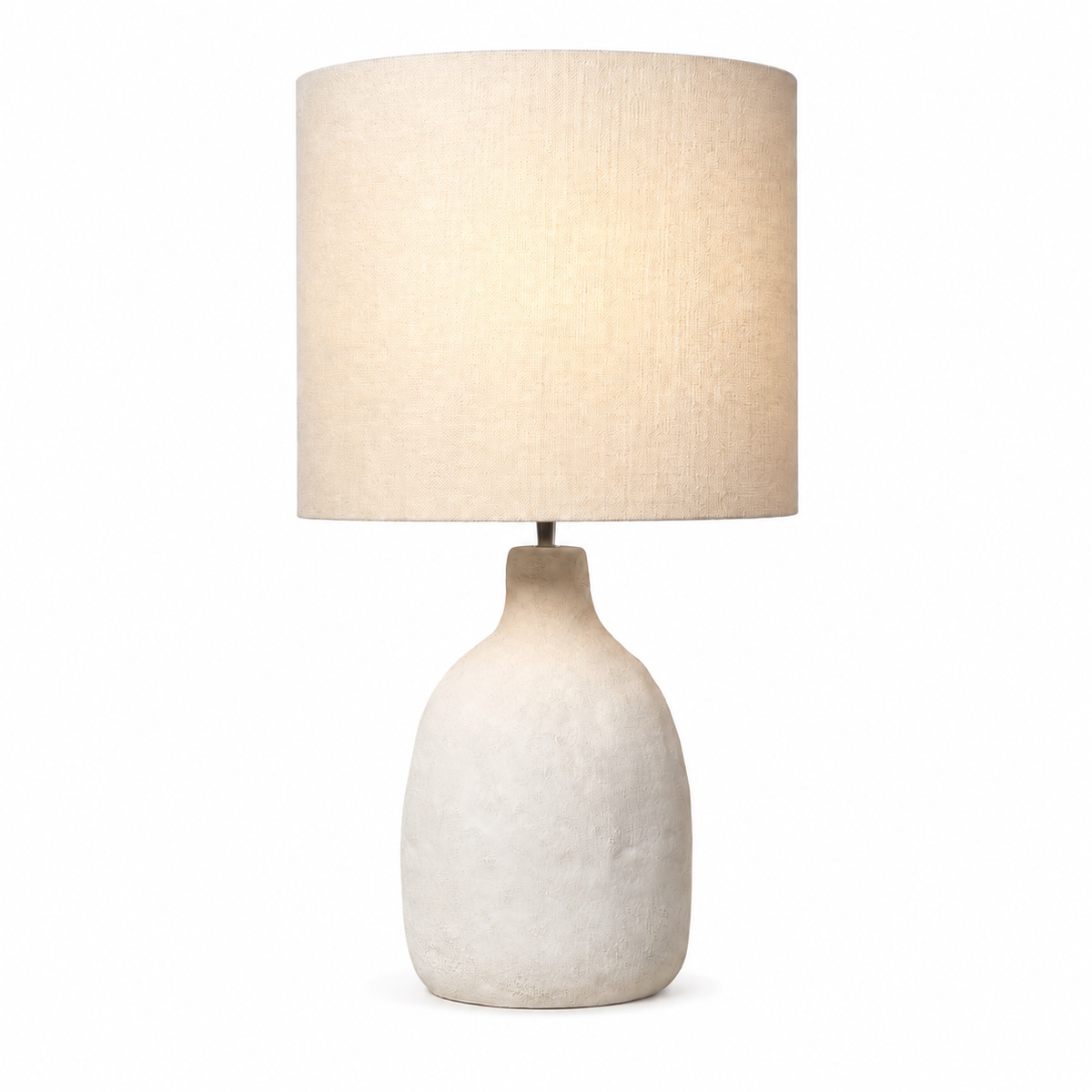 Front view of the Oskar 1916E table lamp with its 1xE27 bulb illuminated, casting a soft warm glow through the textured white shade. The white sand finish and 31 cm tall silhouette deliver atmospheric, refined lighting for modern living rooms and bedrooms, by Marcottestyle.