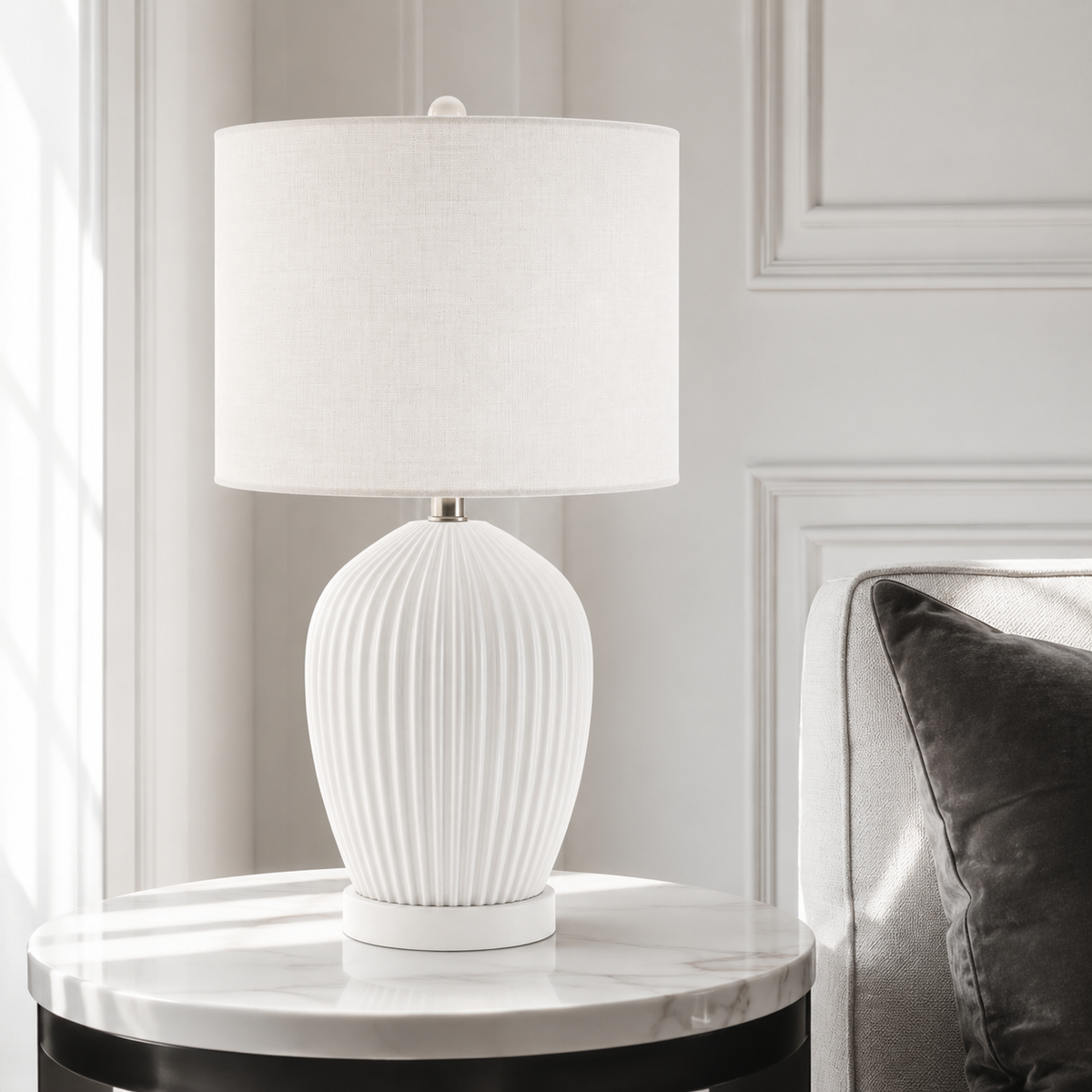 In-room lifestyle view of the white Zola 4688B table lamp, from the Zola family, placed in a modern living-room setting with classic framing and velvet carpet, 1xE27 bulb, 38 cm height and 30 cm shade base, transitional timeless silhouette, by Marcottestyle.