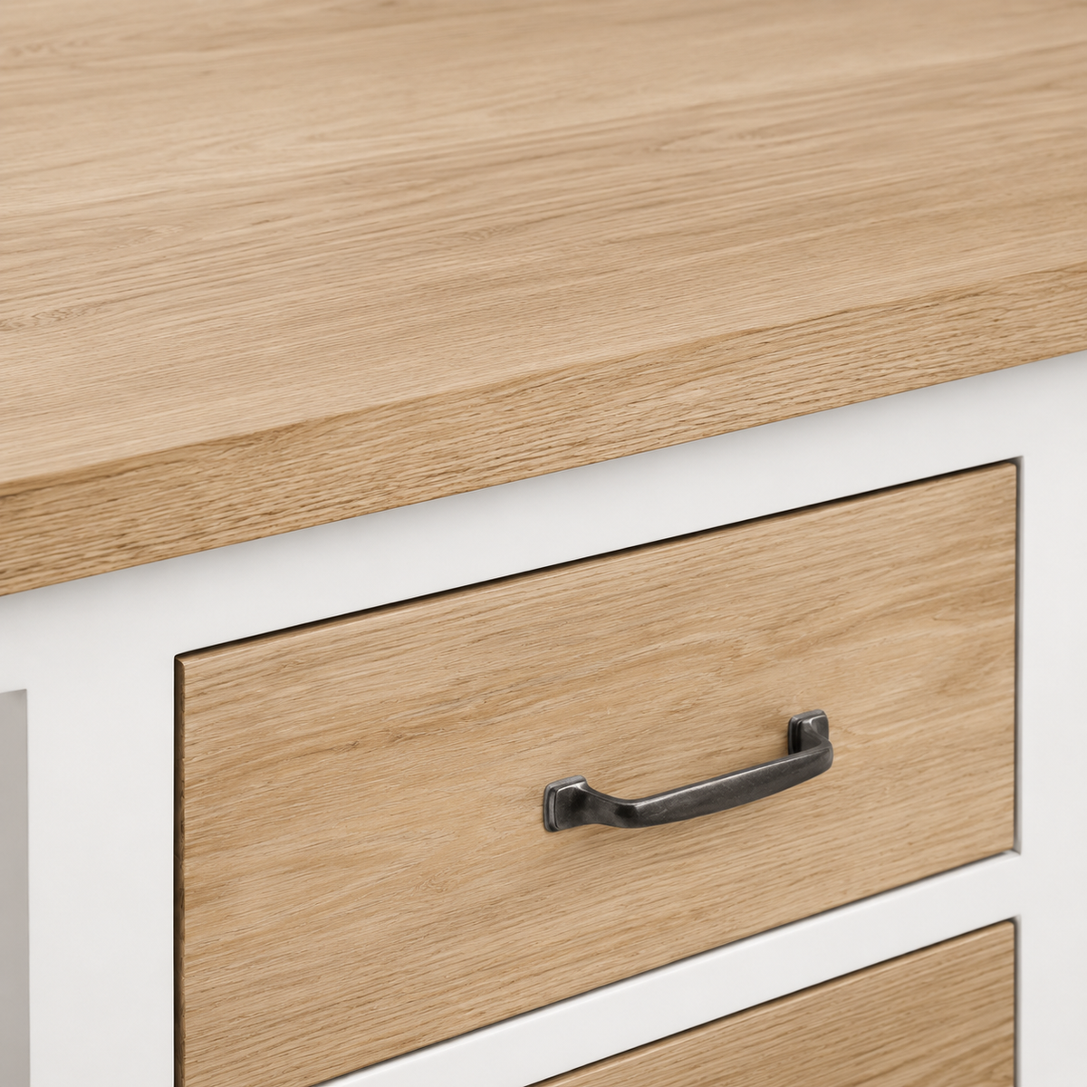 Detail of natural oak drawer front with aged metal handle on the white Seabrook bathroom vanity