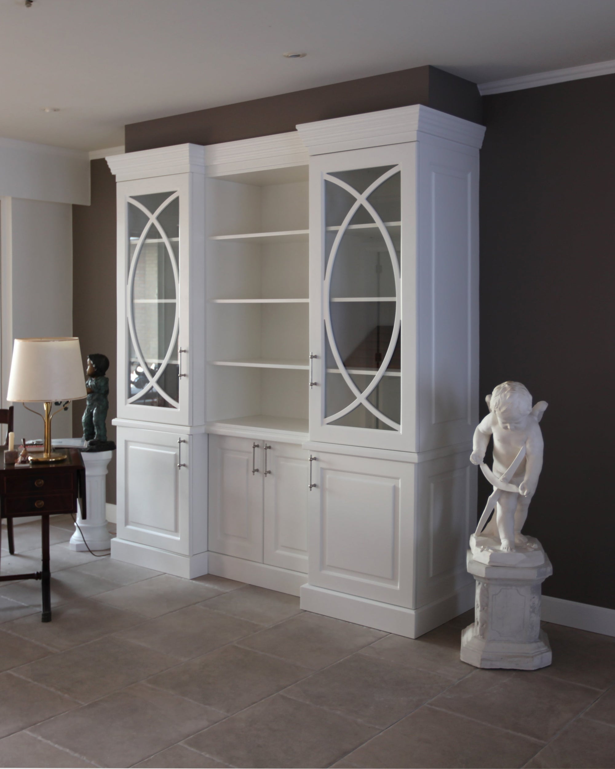 Decorative interior with white bookshelf, statue, and dark walls