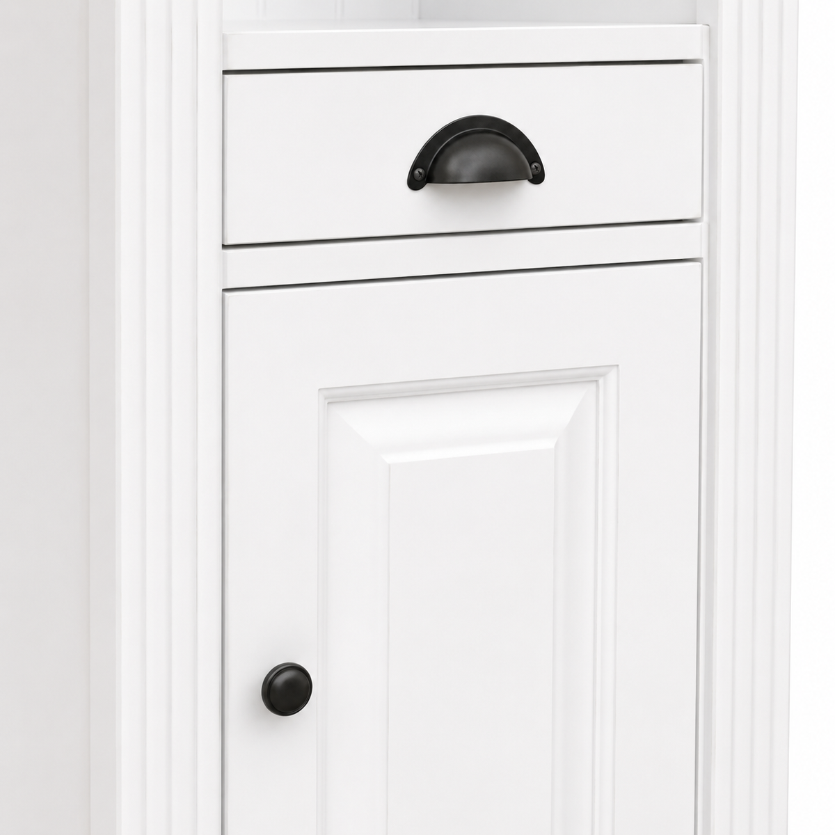 Detail of black cup drawer handle and round knob on the white Westcott bathroom cabinet door