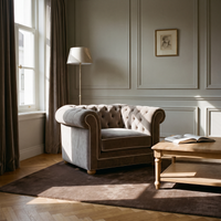 Chesterfield loveseat in greige velvet with white piping in a classic living room