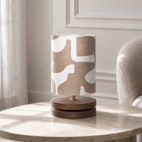 Lampadaire Oskar 1408T avec light turned on, warm glow softly visible through the linen shade fabric, natural metal base on white background avec subtle shadows by Marcottestyle