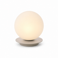 Table Lamp Stella 8417I with light turned on showing warm soft glow through beige fabric shade on pure white background by Marcottestyle