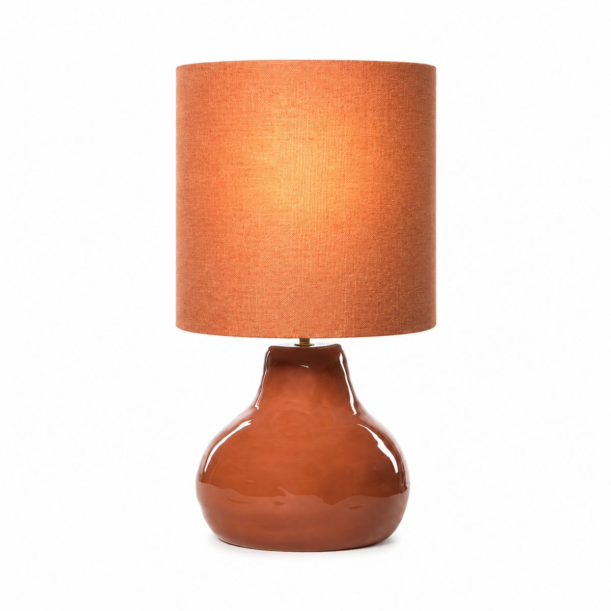 Table Lamp Stella 2575R with light turned on, warm glow softly visible through fabric shade, rustic terracotta ceramic base on white background, professional product photography by Marcottestyle